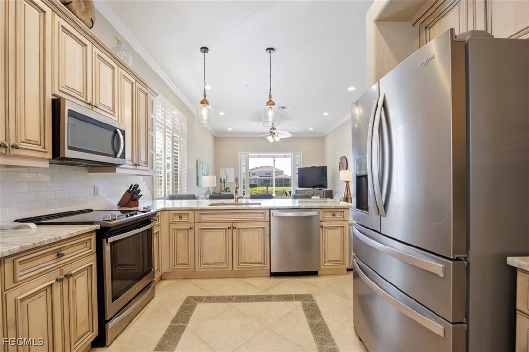 9159 Spring Mountain Way Fort Myers, FL 33908 - Photo 10 of 48 a kitchen with stainless steel appliances granite countertop a refrigerator a stove a sink and a microwave
