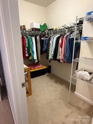 a view of walk in closet with clothes and shoes