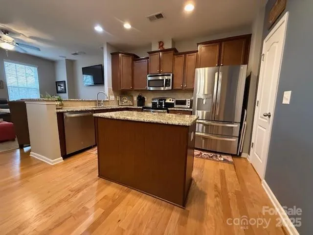 a kitchen with wooden floors and white stainless steel appliances