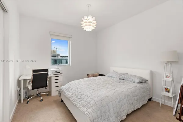 a bedroom with a bed and a chandelier