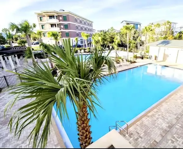 a view of a swimming pool with a lawn chairs and potted plants