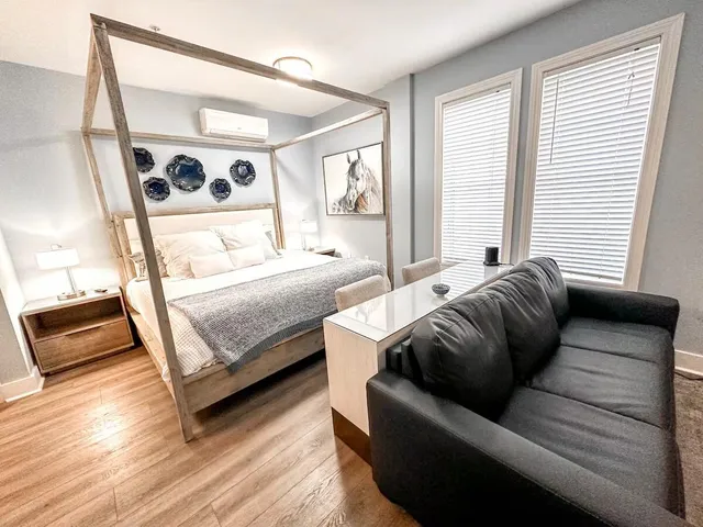 a bedroom with a bed couch and a window