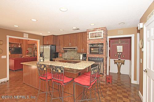 9628 Beauclerc Bluff Road Jacksonville, FL 32257 - Photo 5 of 31 a kitchen with stainless steel appliances kitchen island granite countertop a refrigerator a stove a sink a dining table and chairs with wooden floor
