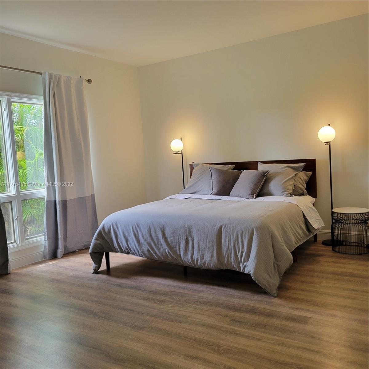 7896 Seville Place, Unit 1501 Boca Raton, FL 33433 - Photo 4 of 9 a bedroom with a bed and wooden floor