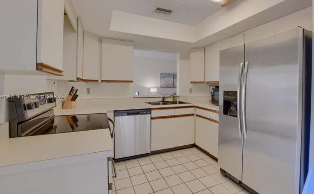 7896 Seville Place, Unit 1501 Boca Raton, FL 33433 - Photo 6 of 9 a kitchen with a refrigerator sink and cabinets
