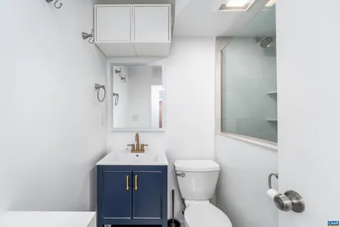 a bathroom with a toilet a sink and mirror
