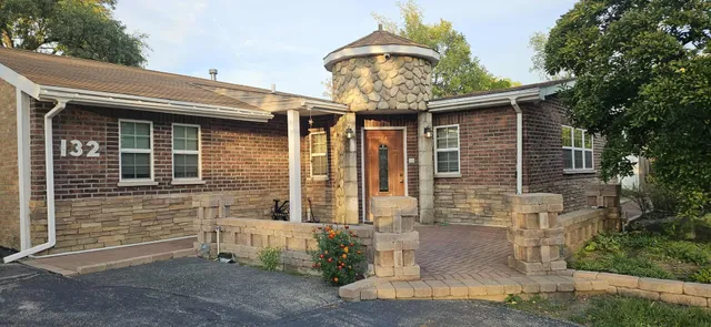a front view of a house with plants