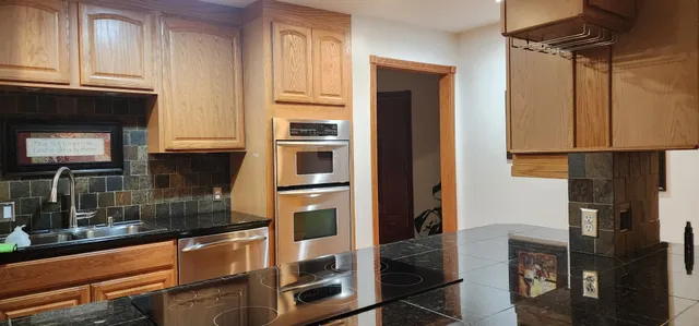 a kitchen with stainless steel appliances granite countertop a refrigerator and a stove top oven