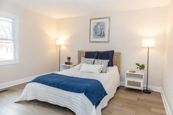 a bedroom with a bed and a lamp on dresser