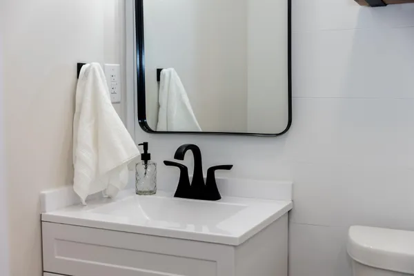 a close view of a sink a mirror and shower in bathroom