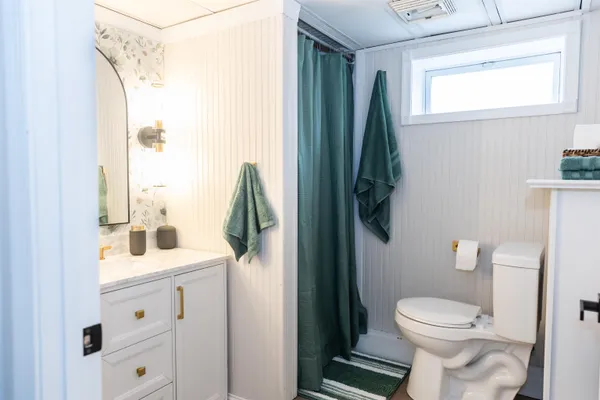 a bathroom with a sink a toilet and shower