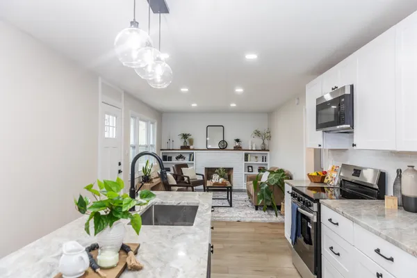 a kitchen with stainless steel appliances granite countertop a sink a stove top oven a counter space and cabinets