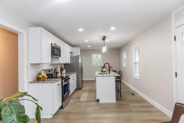 a kitchen with stainless steel appliances a sink a stove top oven a counter space and cabinets