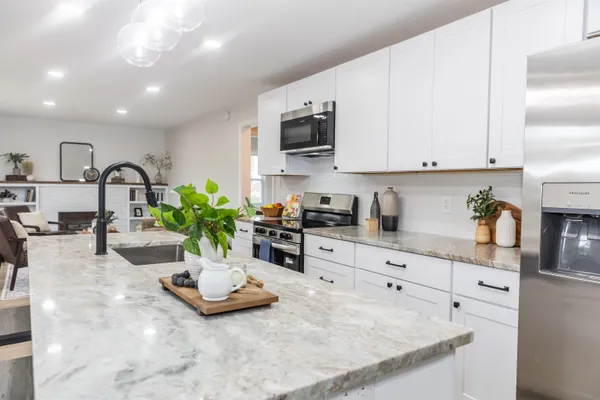 a kitchen with sink refrigerator and stove