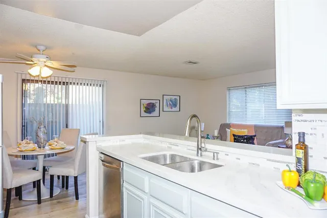 a kitchen with granite countertop a sink and a refrigerator