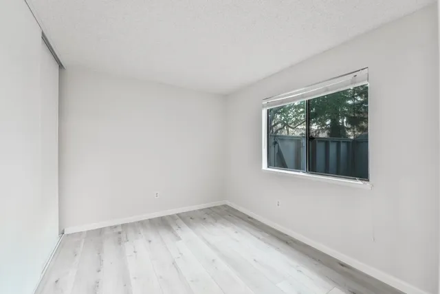 an empty room with wooden floor and sliding door