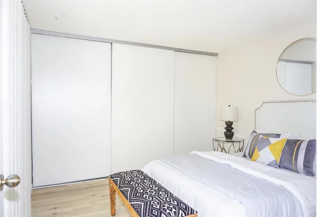 a bedroom with a bed and a painting on the wall