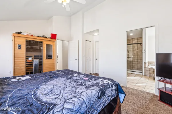 a bedroom with a bed and a flat tv screen tv