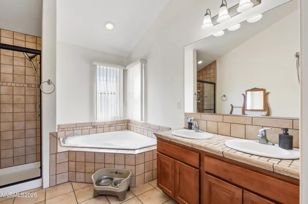 a bathroom with a double vanity sink a mirror and a bathtub