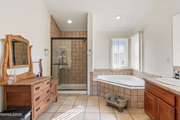 a spacious bathroom with a double vanity sink a mirror and a bathtub
