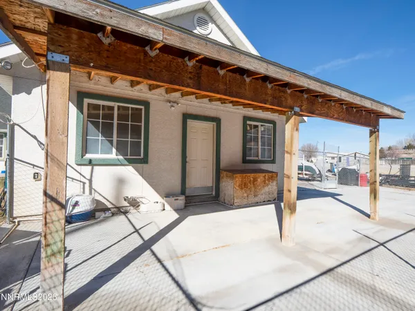 a view of a house with a barbeque and wooden stairs