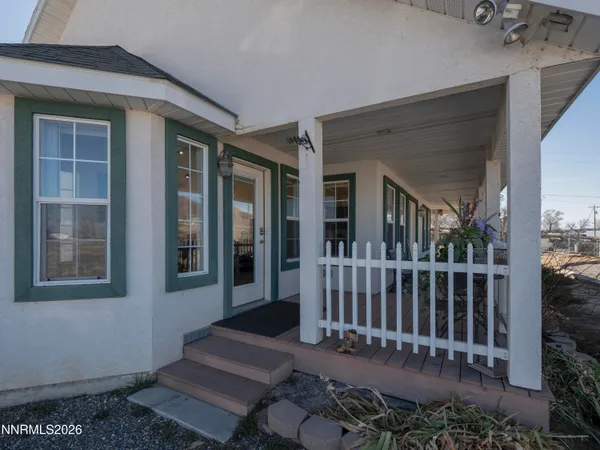 a view of a house with a small yard and wooden floor and fence