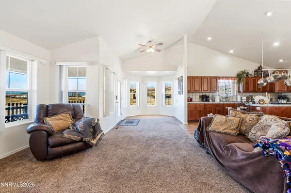 a living room with furniture kitchen view and a chandelier