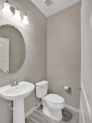 a bathroom with a sink toilet and a mirror