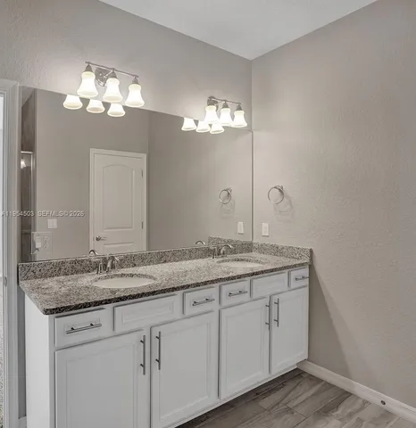 a bathroom with a granite countertop sink a large mirror and vanity