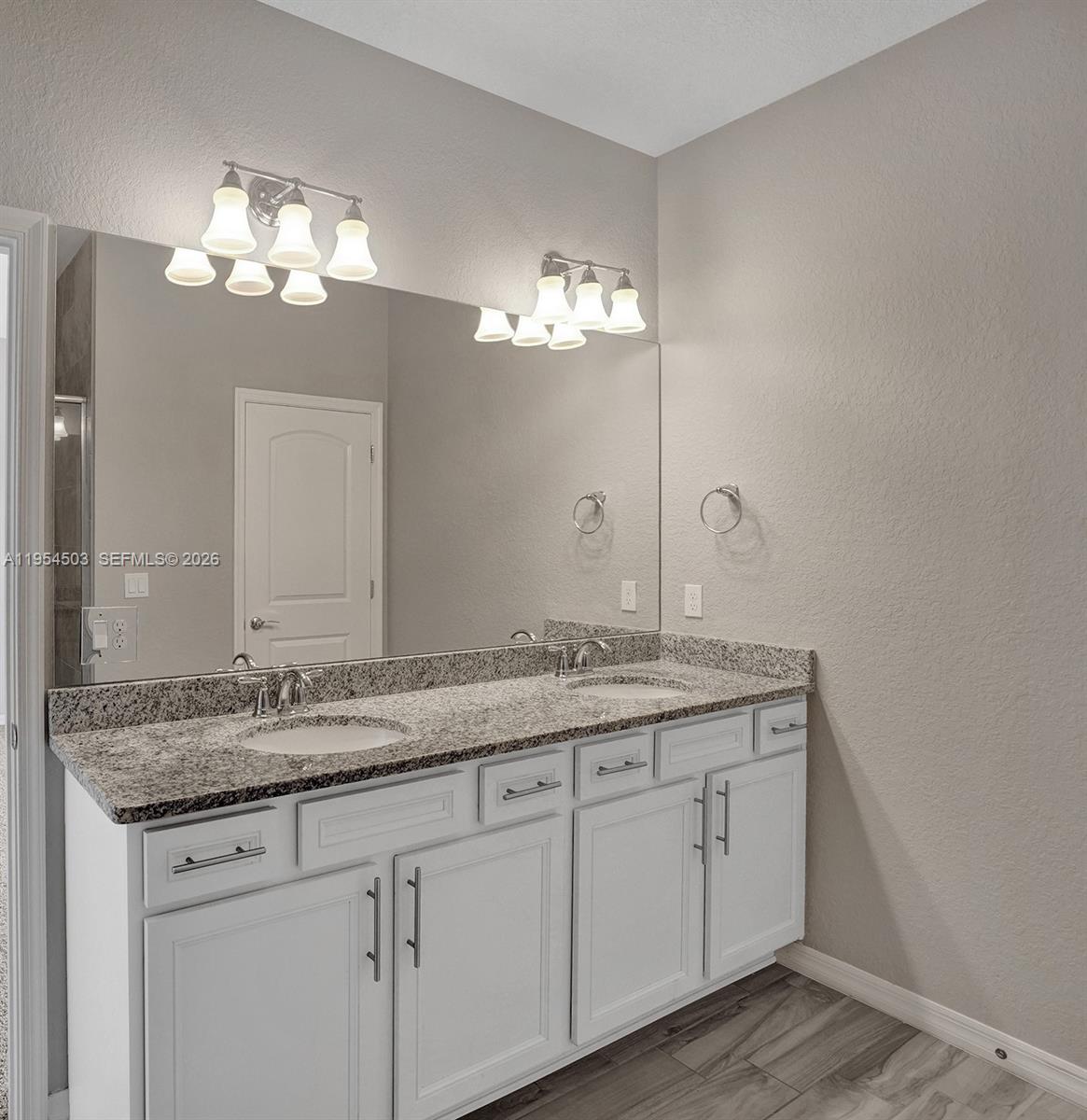 8330 Rearing Lane Lake Worth, FL 33467 - Photo 16 of 39 a bathroom with a granite countertop sink a large mirror and vanity