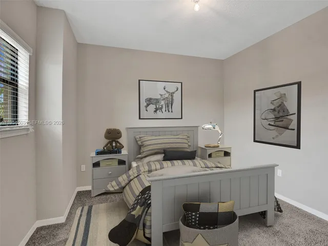 a bedroom with a bed and a painting on the wall