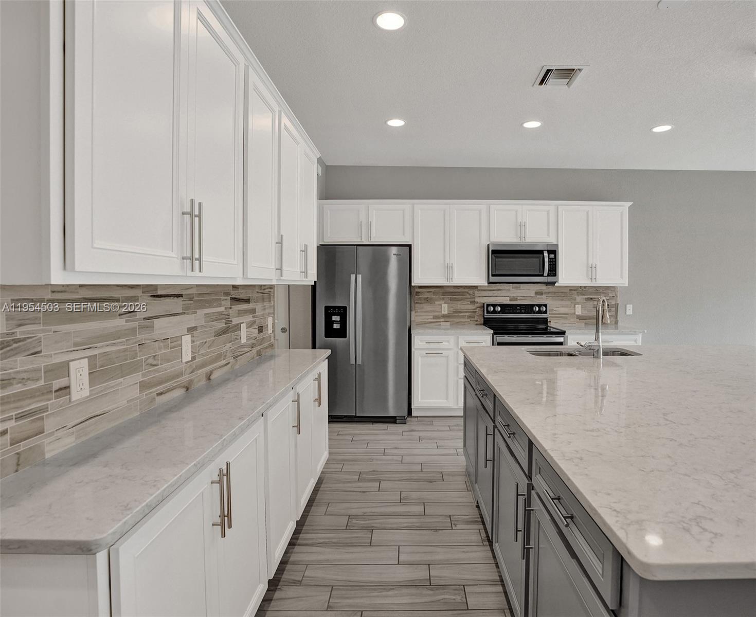 8330 Rearing Lane Lake Worth, FL 33467 - Photo 5 of 39 a kitchen with kitchen island granite countertop a sink counter top space stainless steel appliances and cabinets