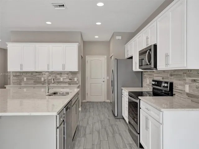 a kitchen with stainless steel appliances a stove sink microwave and cabinets