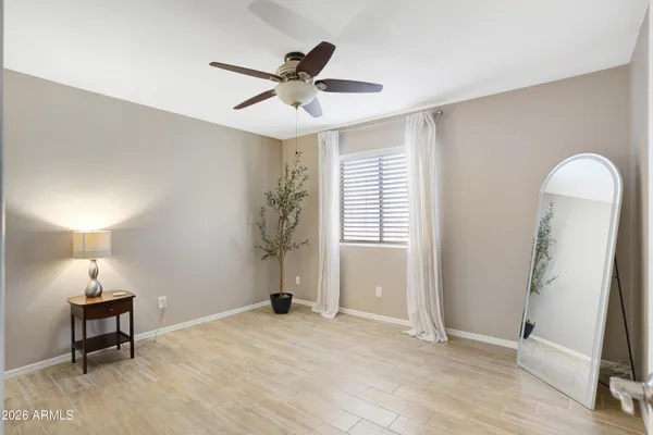 a view of empty room with wooden floor and fan