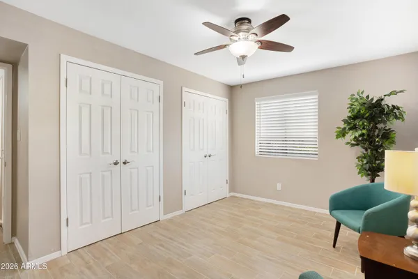 a view of a livingroom with a potted plant a ceiling fan and a window