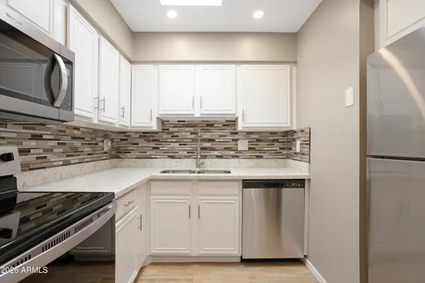 a kitchen with granite countertop white cabinets and appliances
