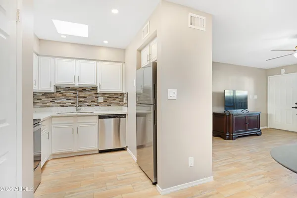 a kitchen with stainless steel appliances white cabinets and a stove top oven