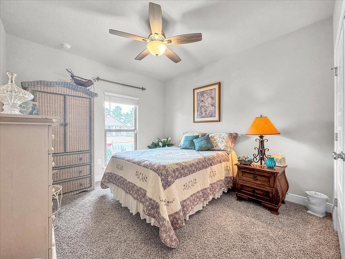 3568 Moonstone Drive Navarre, FL 32566 - Photo 16 of 39 a bedroom with a bed and a chandelier