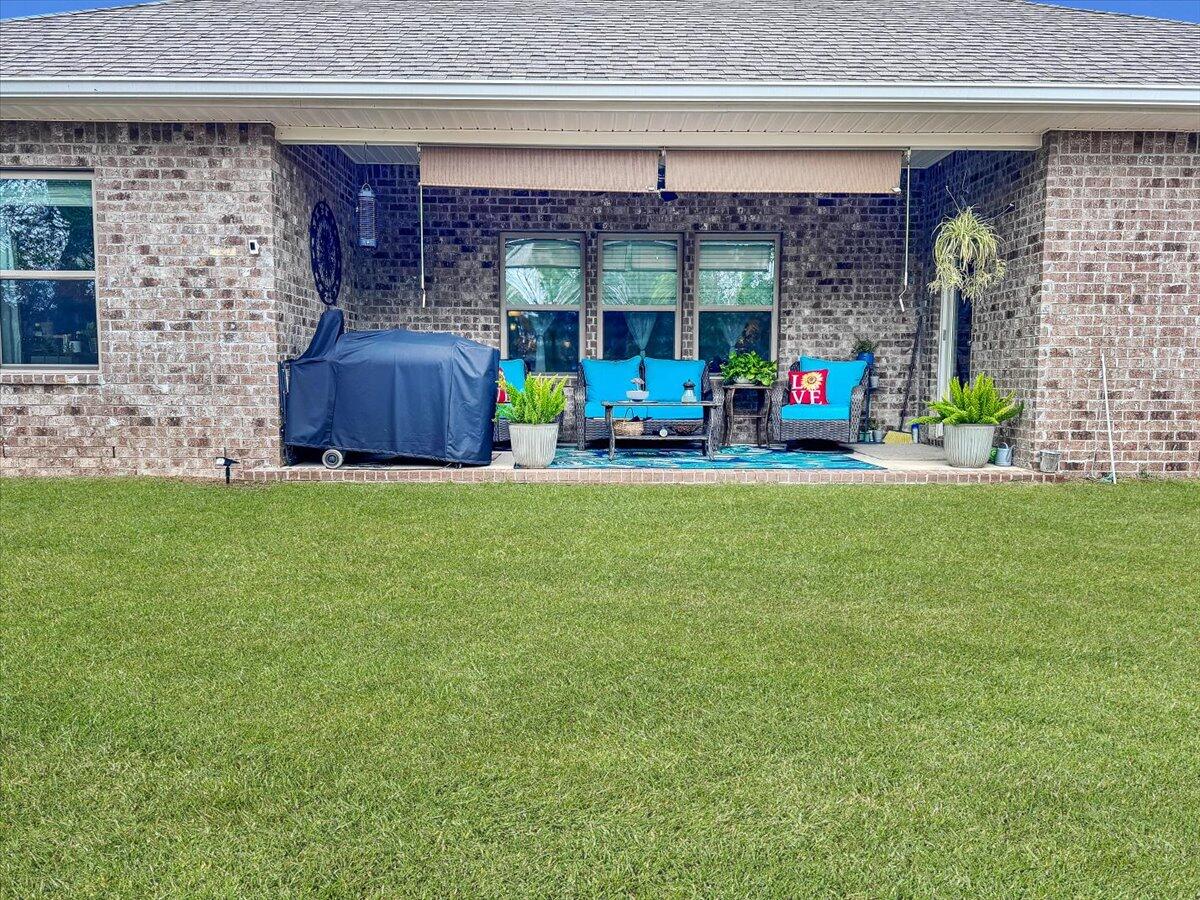 3568 Moonstone Drive Navarre, FL 32566 - Photo 36 of 39 a view of a chair and tables in the back yard of the house
