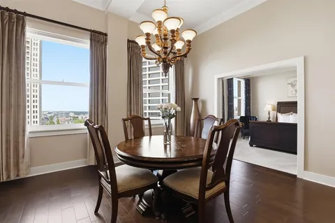 a view of a dining room with furniture a chandelier and wooden floor