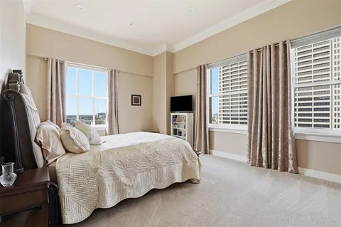 a bedroom with a bed closet and a flat tv screen