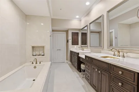 a spacious bathroom with a tub double sink and mirror