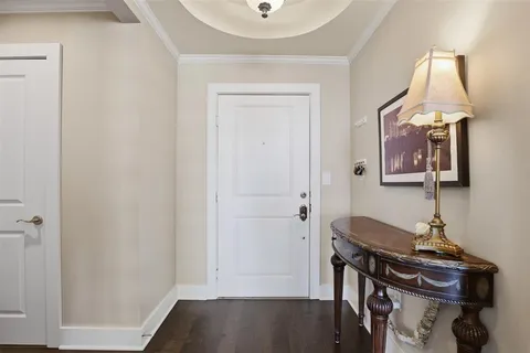 a view of a workspace room with wooden floor cabinet and chandelier