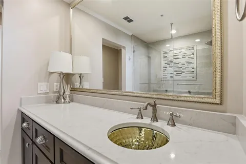 a bathroom with a granite countertop sink a mirror and vanity