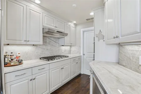 a kitchen with white cabinets and appliances