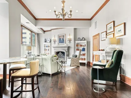 a living room with furniture fireplace and a large window