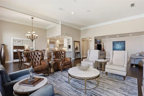 a living room with furniture a dining table and a chandelier