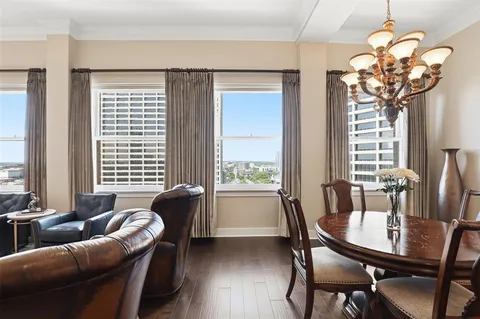 a living room with furniture a chandelier and a large window