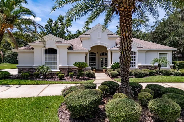 a front view of a house with a garden and plants