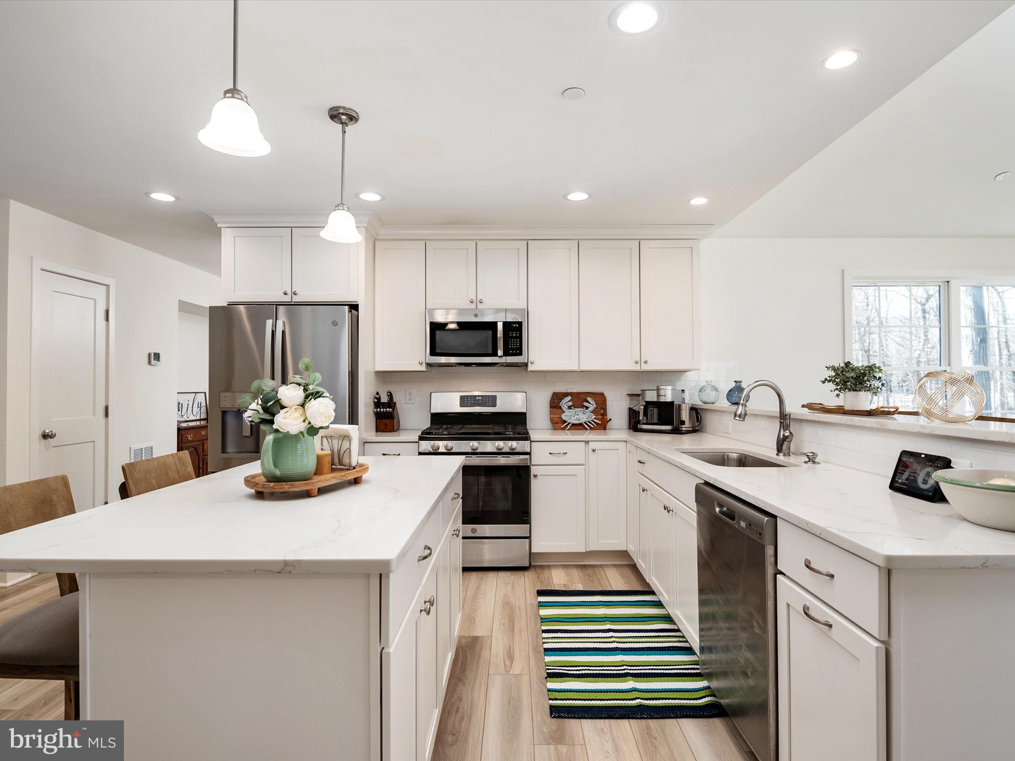 8412 Maryland Road Pasadena, MD 21122 - Photo 18 of 61 a kitchen with a sink a stove top oven and cabinets
